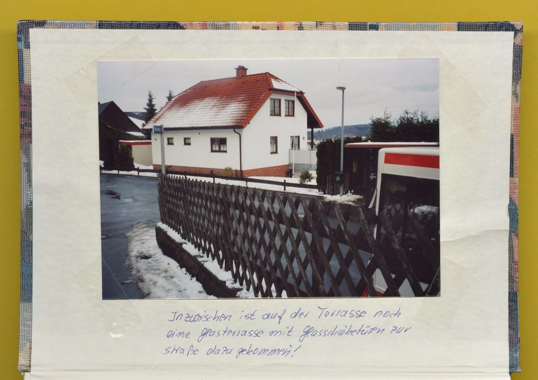 Photo: A page from a notebook featuring a photo of a single-family home and a section of street.