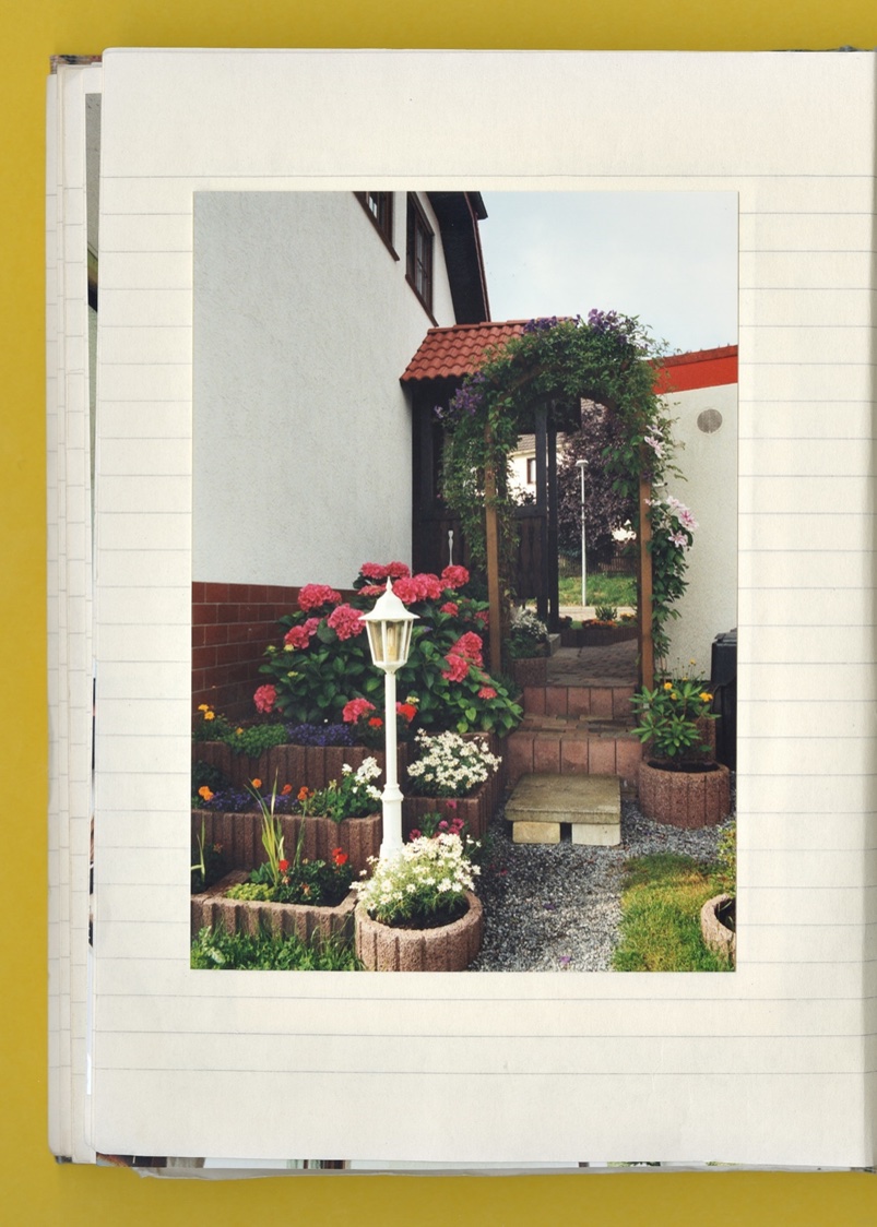 Photo: A page from a notebook featuring a photo showing a section of the garden of a single-family home.